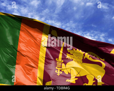 Wehende Flagge von Sri Lanka bis gegen den blauen Himmel in der Nähe Stockfoto