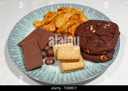 9. Juni 2019. Eine Platte mit hohem Zucker behandelt, einschließlich Schokolade, Kekse, Chips, Schokolade, Kekse, Schokolade Wabe Kugeln bedeckt Stockfoto