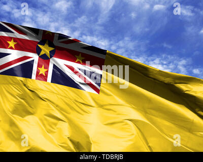 Wehende Flagge von Niue close up gegen den blauen Himmel Stockfoto