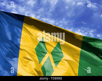 Wehende Flagge von Saint Vincent und die Grenadinen close up gegen den blauen Himmel Stockfoto