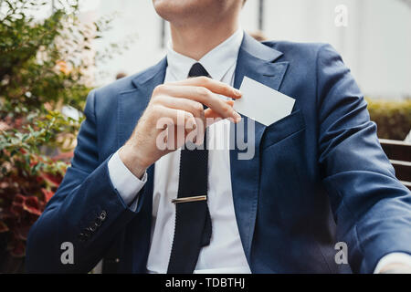 Nahaufnahme von Geschäftsmann, blank Business Card in seinem blauen Jacke Tasche. Von der Seite. Stockfoto