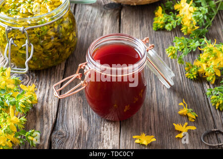 Eine Flasche roten Öl aus Johanniskraut Blüten erfolgen Stockfoto
