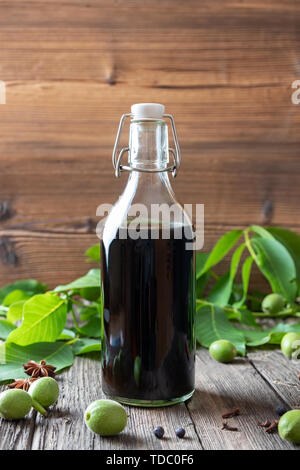 Eine Flasche hausgemachten Likör, der aus unreifen Nüssen und Gewürzen Stockfoto