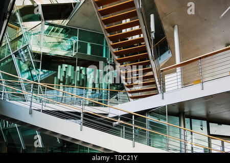 Berlin, Deutschland - Juni 1, 2019: Treppen, die sich schneiden, in ein architektonisches Design Gebäude mit transparenten Kristallen. Stockfoto