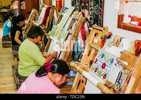 Göreme, Türkei - 14. Juni 2019: Artisan Frauen weben türkischen Teppichen auf alten Webstühlen. Stockfoto