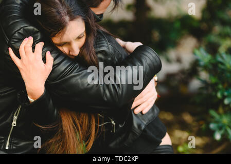 Paar in der Liebe mit gelöster Probleme, Freund Konsolen seine Freundin von ihr umarmen. Stockfoto