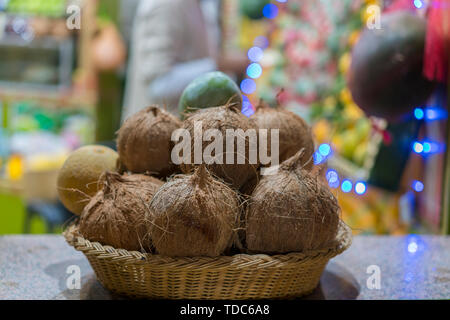 Kokosnüsse in einem Korb auf einem Basar. Haufen Kokosnüsse im Korb auf dem Markt Stockfoto