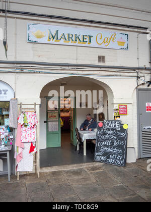 Ein Mann sitzt auf einem Stuhl an einem Tisch draußen Der Markt Cafe in der abergavenny Halle Stockfoto