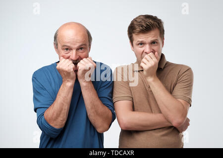 Zwei Männer aus Mund mit den Händen in der Angst Stockfoto