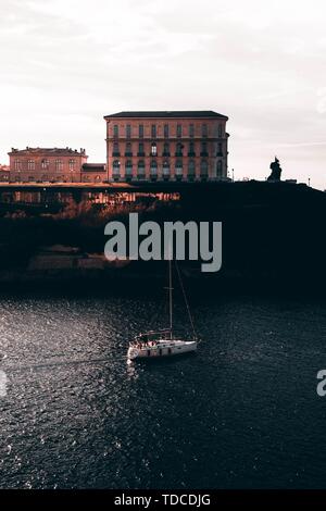 Boot Segeln auf einem Fluss in Marseille, Frankreich mit erstaunlichen Architektur im Hintergrund Stockfoto