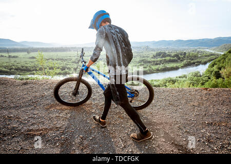 Professionelle gut ausgestattete Radfahrer reiten Fahrrad auf der Rocky Mountains mit Blick auf die schöne Landschaft bei Sonnenuntergang Stockfoto