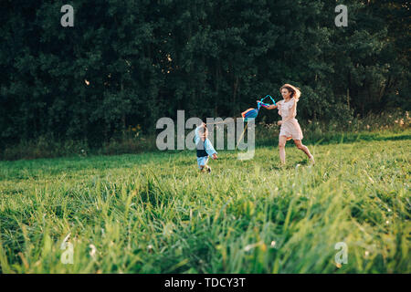 Glückliche Familie, Mutter und Sohn einen Kite auf die Natur bei Sonnenuntergang Stockfoto