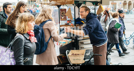 Straßburg, Frankreich - 28 Oktober 2017: Ambulante männliche Verkäufer von heissen Kastanien marron chauds auf den Straßen der französischen Stadt Kunden mit Bio-lebensmitteln traditionellen elsässischen Street Food serviert Stockfoto