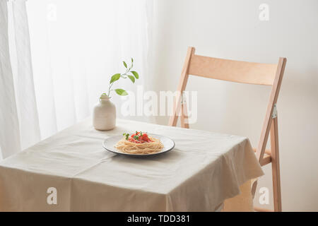 Handgemachte Pasta mit Ragout Soße auf Platte auf Vintage White Tisch mit Sieb und Blumen Stockfoto