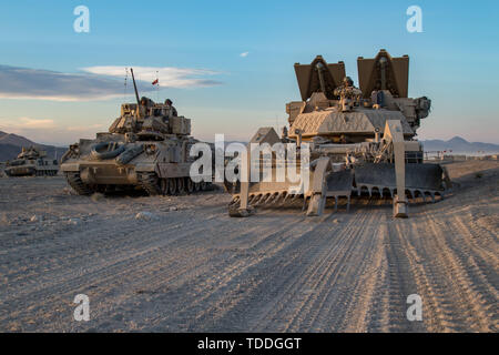 Soldaten von einem Co, 116 Brigade Engineer Battalion, Position, ihre M 1150 Assault Breacher Fahrzeug während einer Live-Fire Training am National Training Center (NTC) in Fort Irwin, Kalifornien, 12. Juni 2019. Die M1150 ist in den USA eine militärische Minen und Sprengstoffen clearing Fahrzeug, mit einer Mine-Pflug und Gebühren ausgestattet sind. NTC ist ein Monat - lange Drehung, die mehr als 4.000 Service Mitglieder aus 31 Staaten, darunter Einheiten aus 13 nationalen Schutz Staaten und Territorien, mit realistischen Ausbildung ihrer Bekämpfung, Unterstützung und Erhaltung Fähigkeiten zu verbessern. (Foto: Cpl. Alisha Grezlik, 115 Stockfoto