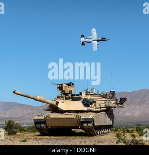 Ein Idaho Air National Guard 10 C Thunderbolt II aus der 124 Fighter Wing fliegt über 2 Bataillon des Idaho Army National Guard, defensive Line 116 Reiterregiment 13 Juni, 2019 am National Training Center in Fort Irwin, Kalifornien. Während NTC die 116 Kavallerie Brigade Combat Team und die 124 Fighter Wing, beide mit Sitz in Boise, haben an der Seite von jeder anderen Einheit, die Bereitschaft und die Kompetenz in Kriegszeiten Missionen der einzelnen Einheit zu bauen geschult. Stockfoto