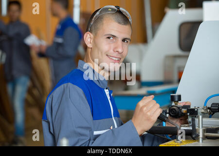 Attraktive junge Mechaniker in Kamera suchen Stockfoto