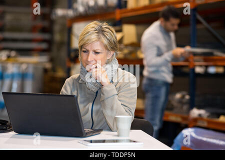 Geschäftsfrau, Arbeiten mit Laptop in ein Lager Stockfoto
