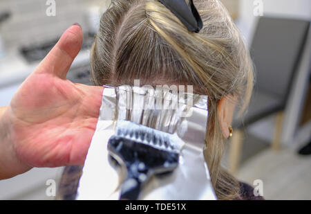 Nahaufnahme von Folie Haar Tönung Prozess und zeigt Folie gemacht. Tönung Pinsel ist die Haarfarbe vor dem Falzen in ein Paket. Stockfoto