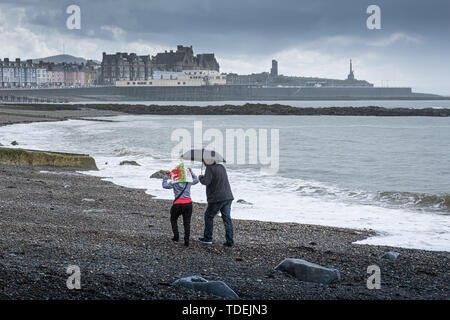 Aberystwyth Wales UK, Samstag, 15. Juni 2019 Deutschland Wetter: Ein paar haben den Strand für sich auf einem grauen und feuchten Nachmittag am Meer in Aberystwyth, West Wales, als die triste nass und sehr unsesonal Juni Sommer" Wetter seinen Einfluß auf das Land Foto Keith Morris/Alamy Live Nachrichten fort Stockfoto