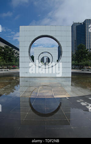 Eine Skulptur des Suzhou Industrial Park mit einem Kreis in den Platz und eine Reihe von Kreisen, und das Wasser nach dem Regen ein Spiegel reflektiert. Stockfoto