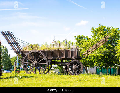 Rustikal Warenkorb. Vintage Holz- Ladewagen. Denkmal in einem modernen Dorf. Stockfoto