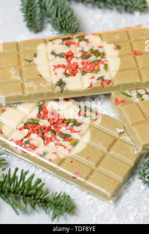 Handgefertigte Pralinen bar. Thema Weihnachten. Weiße Schokolade mit Pistazien und getrockneten Früchten Kirschen. . Platz kopieren Stockfoto