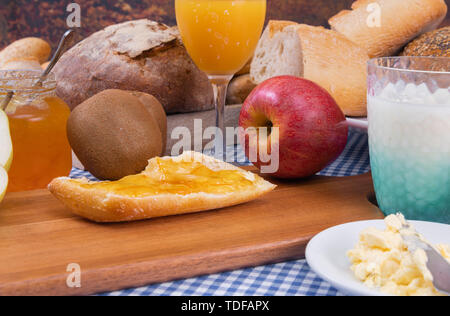 Kiwi, Apfel, Brot mit Marmelade, Joghurt und Orangensaft - gesundes Frühstück - Close-up Stockfoto