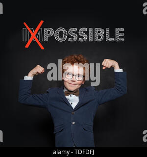 Zuversichtlich starkes Kind in Anzug mit möglich Text auf schwarzen Brett. Erfolg, Chancen und Konzept entwickeln. Stockfoto