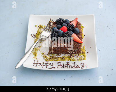 Happy Birthday in Sahnehäubchen auf Schokolade Kuchen geschrieben Stockfoto