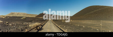 International Observatory in den Teide Nationalpark. Land straße verläuft in schwarze Vulkane im Vordergrund. Windiger Tag mit strahlend blauem Himmel und amazinc Stockfoto