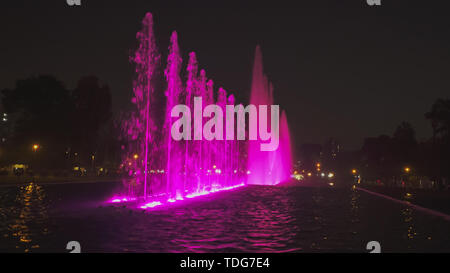 Night Shot aus einem lila beleuchteten Springbrunnen auf der Magic Water Circuit in Lima, Peru Stockfoto