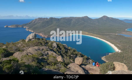 Weitwinkelaufnahme der Wineglass Bay und zwei Wanderer aus Mt Amos an der Ostküste von Tasmanien, Australien Stockfoto