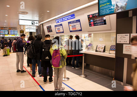 Japaner und ausländische reisende Passagiere warten und stehen in der Warteschlange für Tickets kaufen MRT Züge von auto Automaten bei Ueno Station auf März Stockfoto