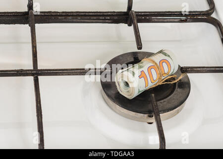 Ein Stapel von 100-Dollar Scheine auf einem Gasherd im Zentrum von Gas Komfort, das Gas brennt nicht. Stockfoto