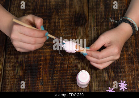 Färbung eine festliche Spielzeug. Pinsel und Spielzeug in die Hand. Spielzeug Eiscreme. Stockfoto