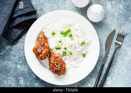 Weißer Reis mit Erbsen und gerösteten Teriyaki Hähnchen Schenkel. Tabelle Ansicht von oben Stockfoto