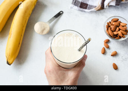 Protein Banane Milchshake oder Smoothie. Des Menschen Hand Glas Gesund vegan vegetarisch Smoothie Stockfoto