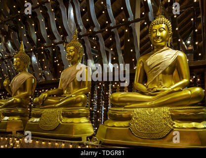 Reihe mit drei goldenen Buddha Statuen sitzen auf Kissen in Seema Malaka Tempel. Stockfoto