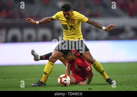 Brasilianische Fußballspieler Paulinho, oben, von Guangzhou Evergrande Taobao passt den Ball gegen einen Spieler von Shanghai SIPG in der 13. Runde während der 2019 chinesischen Fußballverband Super League (CSL) in Shanghai, China, 14. Juni 2019. Shanghai SIPG wurde von Guangzhou Evergrande Taobao 0-2 besiegt. Stockfoto