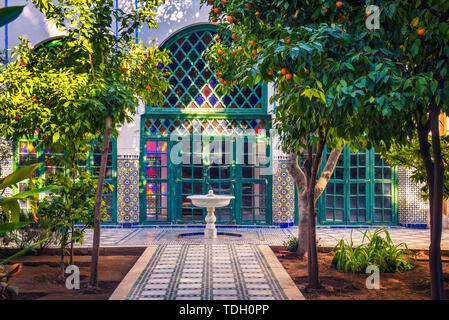 Kleine weiße Fontaine unter Orangenbäumen von Jardin Majorelle, Marrakech, Marokko Stockfoto