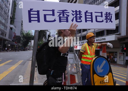 Hongkong, China. 16 Juni, 2019. Frau Anzeige ein Plakat, das liest HONGKONG MÜSSEN VON UNS GERETTET WERDEN. Tausende von Bürgerinnen und Bürgern in der zweiten Massenprotest heute teilgenommen haben, anspruchsvolle Für die vollständige Rücknahme der umstrittenen Auslieferung Rechnung, (auch als flüchtige Straftäter Verordnung bekannt), fordert Rücktritt von Chief Executive Carrie Lam. Juni-16, 2019 Hong Kong. ZUMA/Liau Chung-ren Credit: Liau Chung-ren/ZUMA Draht/Alamy leben Nachrichten Stockfoto