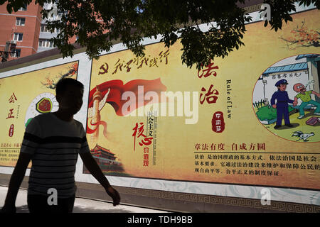 Peking, China. 14 Juni, 2019. Ein Mann hinter einem Propaganda banner beschreiben die Werte der Chinesischen Kommunistischen Partei an den Straßen in Peking. Quelle: Andrea Verdelli/SOPA Images/ZUMA Draht/Alamy leben Nachrichten Stockfoto