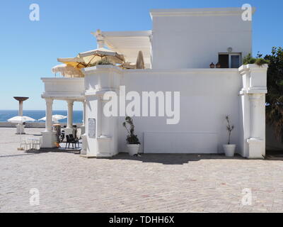 Weißen Gebäuden der Afrikanischen touristischen Gegend in der Nähe von Höhlen von Herkules am Meer in Marokko mit klaren blauen Himmel in 2019 warmen sonnigen Sommertag im April. Stockfoto