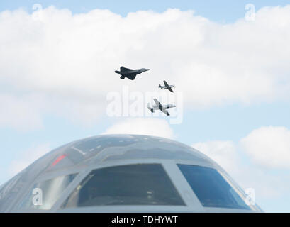 Eine F-22 Raptor, P-51 Mustang und ein A-10 Thunderbolt II fliegen in Formation über eine B-2 Stealth Bomber am 15. Juni 2019, an Whiteman Air Force Base, Missouri. Die Flugzeuge flogen zusammen als Teil der F-22 Raptor Demonstration Team Erbe performace während der 2019 Flügel über Whiteman für Luft- und Raumfahrt zeigen. (U.S. Air Force Foto: Staff Sgt. Kayla Weiß) Stockfoto