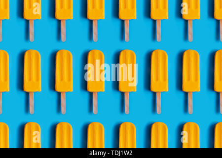 Muster aus hellen gelben mango Eis am trendigen Blau pastell Hintergrund. Sommer Minimalismus Hintergrund. Stockfoto