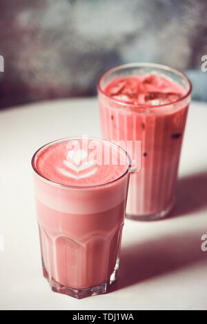 Zwei trendige Rote Beete lattes mit Latte Art auf Tisch im Café. Gesundes Getränk Konzept. Stockfoto