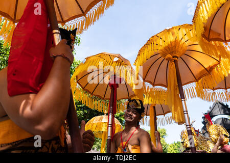 DENPASAR/INDONESIEN - 15. JUNI 2019: Gruppe der Balinesische Tänzerin in ethnischen Kostüme mit traditionellen bunten Schirme am hinduistischen Zeremonie Parade während Templ Stockfoto