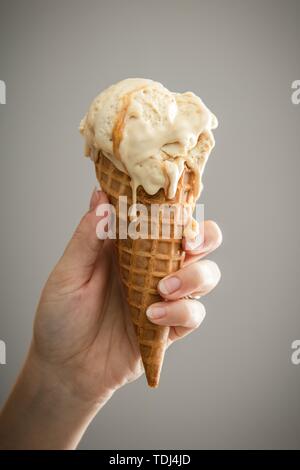 Eine Hand mit einem schmelzenden Karamell-Eis Stockfoto