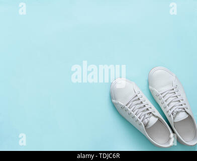 Weißes Leder Sneakers auf blauem Hintergrund. Paar trendige Mode weißen Sport Schuhe oder Turnschuhe mit Kopie Platz für Text oder Design. Overhead shot der neuen weißen Turnschuhen. Top View oder flach. Stockfoto